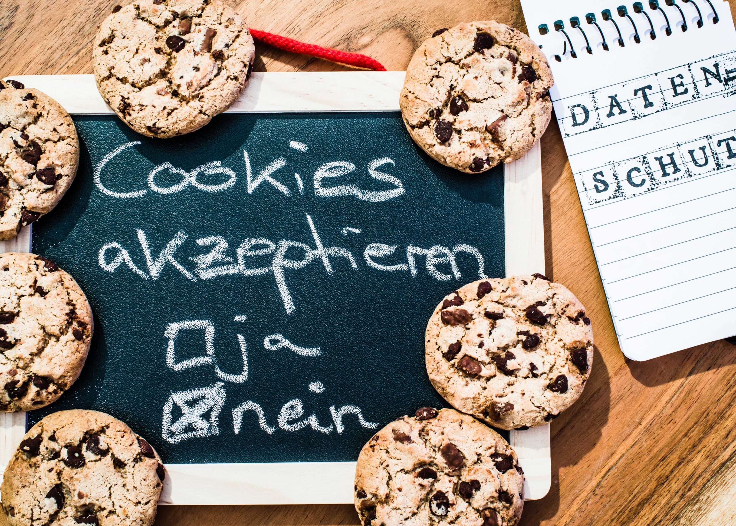 Neue Cookie-Richtlinien: Cookies liegen auf einer Schiefertafel, auf der Steht Cookies akzeptieren und zwei Ankreuzkästchen Ja und Nein. Das Kreuz ist bei Nein gesetzt. Daneben liegt ein Block mit dem Aufdruck Datenschutz.